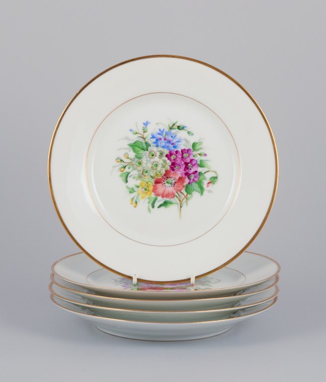 Bing & Grøndahl, Denmark. A set of five porcelain plates hand-painted with various polychrome flower motifs and gold rim.