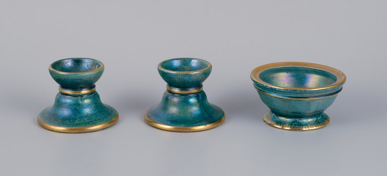 Josef Ekberg for Gustavsberg, Sweden.A pair of candle holders and a small bowl in ceramic. Glaze in blue-green tones with a gold rim.