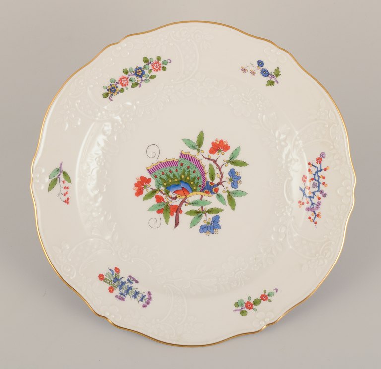 Meissen, Tyskland. Middagstallerken håndmalet med sommerfugl på gren og polykrome blomstermotiver. Guldkant.