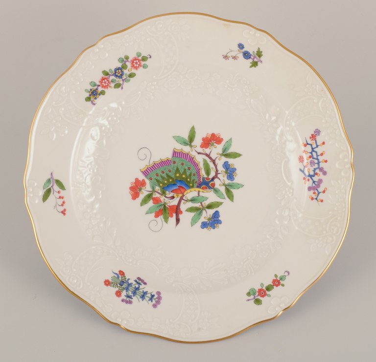 Meissen, Tyskland. Middagstallerken håndmalet med sommerfugl på gren og polykrome blomstermotiver. Guldkant.