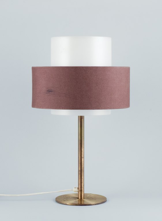 Luxus, Sweden. Large table lamp in brass with a shade in plastic and brown fabric.