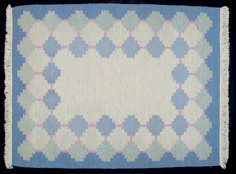 Swedish textile artist. Handwoven wool carpet in Rölakan technique. Modernist design. Blue and pink colors in a geometric pattern.