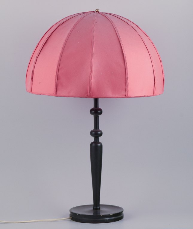 Josef Frank (1885-1967) for Svenskt Tenn, Sweden. Large Art Deco table lamp with a dark pink fabric shade and a black wooden base.