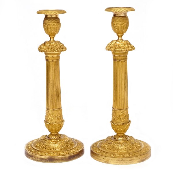 Par lueforgyldte bronze lysestager med kannelerede stammer. Rigt dekoreret med stiliserede blomster og bladværk. Frankrig ca. år 1820. H: 34cm