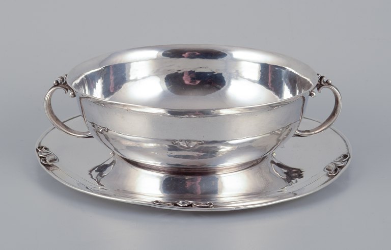 Harald Nielsen for Georg Jensen. Skål med hanke på tilhørende undertallerken i sterlingsølv.