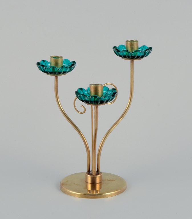 Gunnar Ander for Ystad Metall, Sweden. Brass candlestick holder with turquoise glass sleeves. For three candles.
