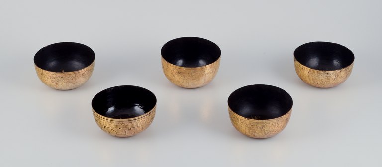 Five Asian bowls made of papier-mâché. Decorated in gold and black with traditional motifs.