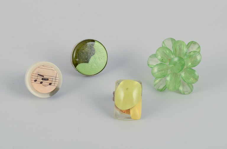 French jewelry artist. Four designer rings in metal and plastic. Various designs in green and yellow colors.