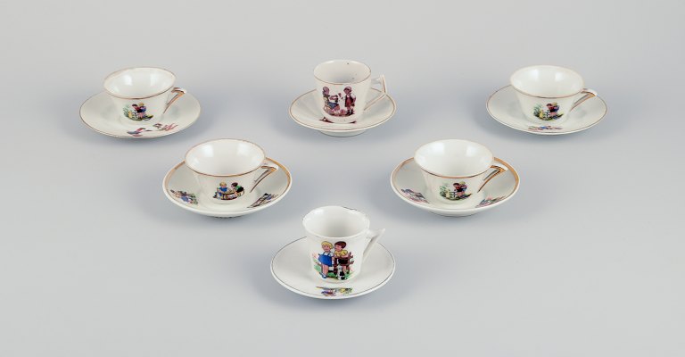 Fransk dukkestel/børneservice i porcelæn.Seks kopper med tilhørende underkopper. Guldkant. Motiver af børn.