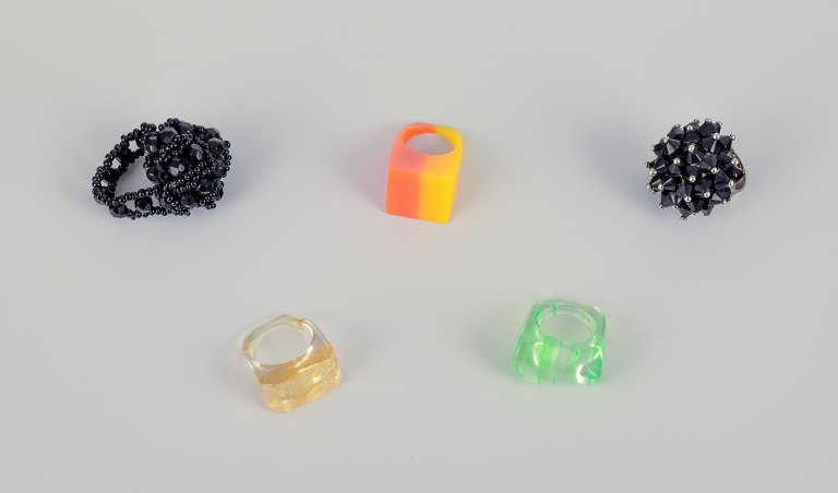 French jewelry artist. Five designer rings in plastic and metal. Striped design with various colors and black beads.