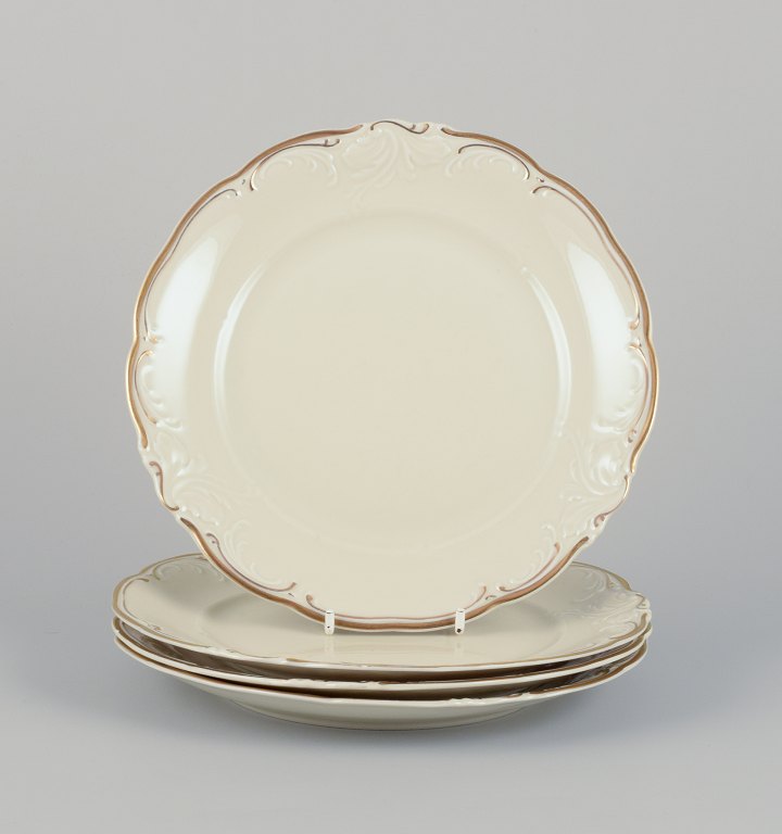 KPM, Polen. Et sæt på fire frokosttallerkner i porcelæn.Cremefarvet, dekoration med guldkant.