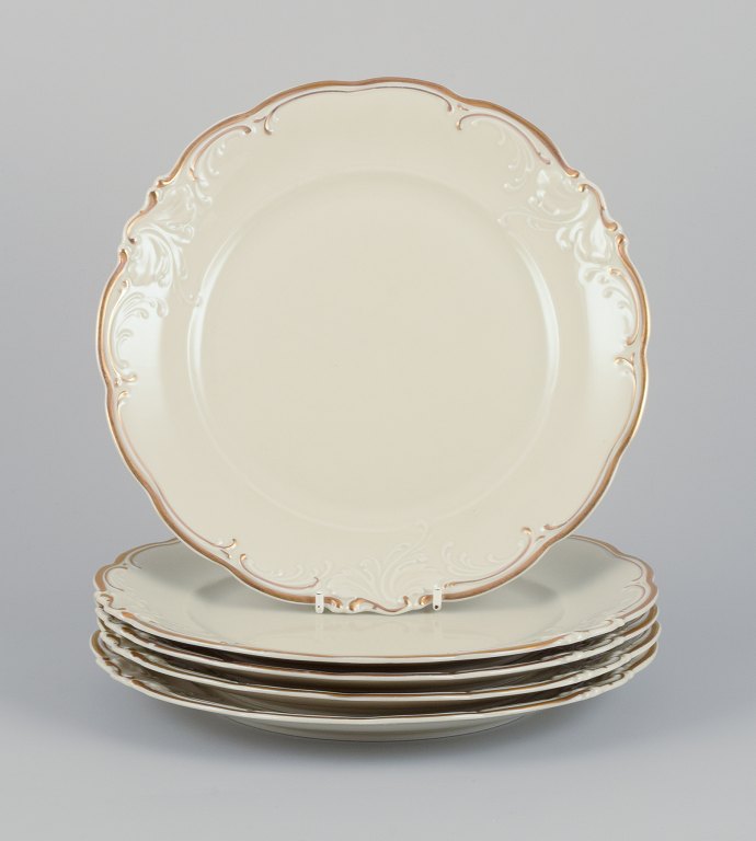 KPM, Poland. A set of five dinner plates in cream-colored porcelain.Decorated with a gold rim.