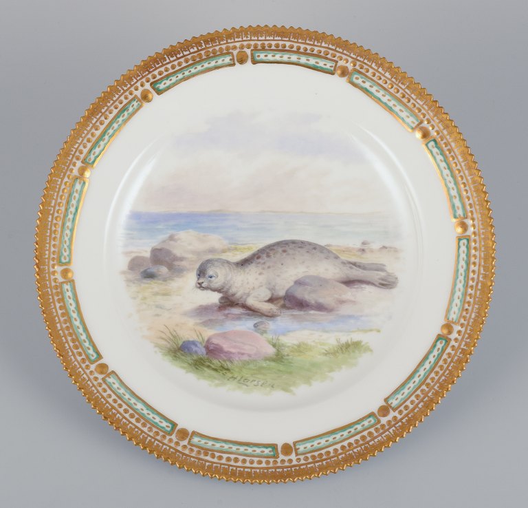 Royal Copenhagen Fauna Danica dinner plate with a motif of a spotted seal on the beach. Hand-painted by H. Larsen.