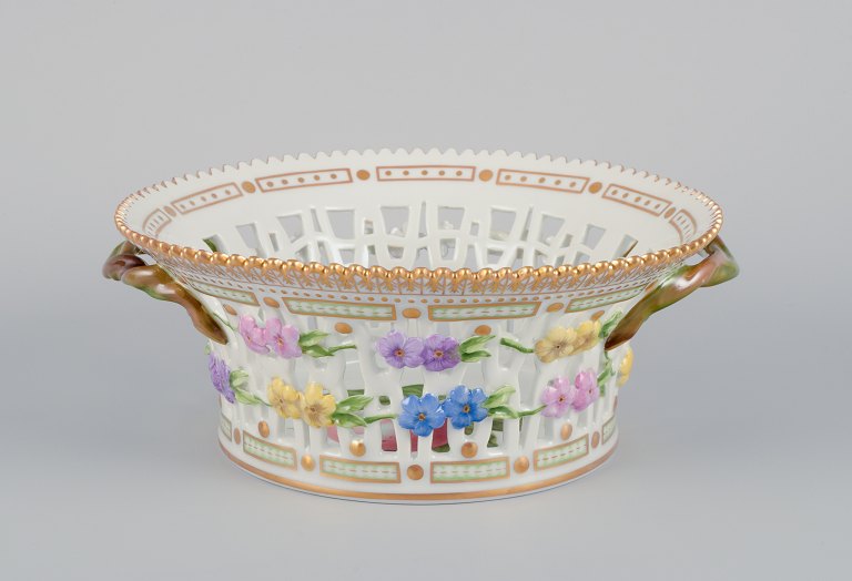 Royal Copenhagen Flora Danica frugtskål af porcelæn, dekoreret i farver og guld med blomster.