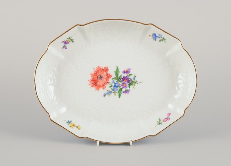Meissen, Germany. Oval porcelain bowl hand-painted with polychrome flowers. Flower garlands in relief. Gold rim.