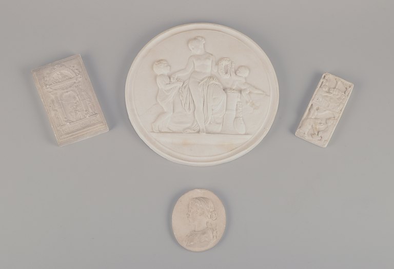 Four plaster reliefs. Large round plaque with Bertel Thorvaldsen motif, religious motif, and a woman in profile.