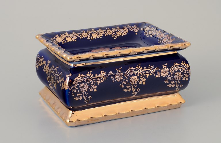 Limoges, Frankrig.  Lågæske i porcelæn. Dekoreret i 22-karat bladguld.Smuk kongeblå glasur. Scène galante.