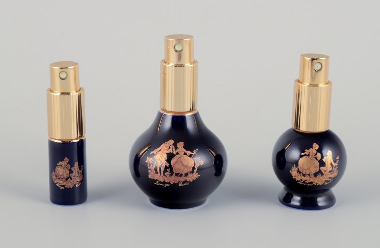 Limoges, Frankrig.  Tre parfumeflakoner i porcelæn. Dekoreret i 22-karat bladguld. Smuk kongeblå glasur. Scène galante.