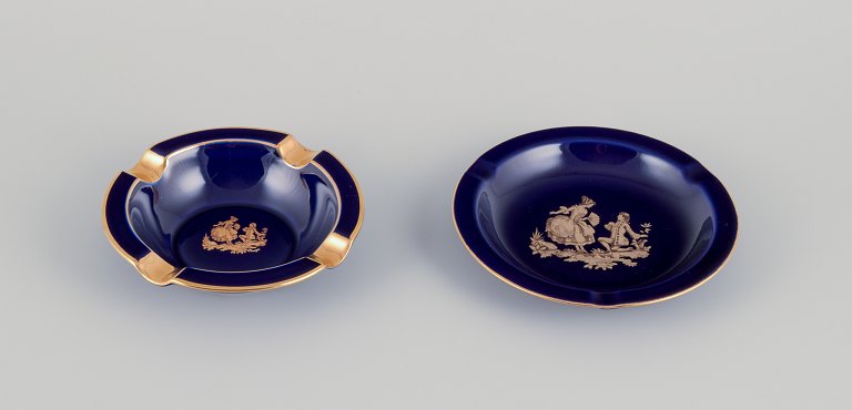 Limoges, Frankrig.  To små skåle i porcelæn. Dekoreret i 22-karat bladguld. Smuk kongeblå glasur. Scène galante.