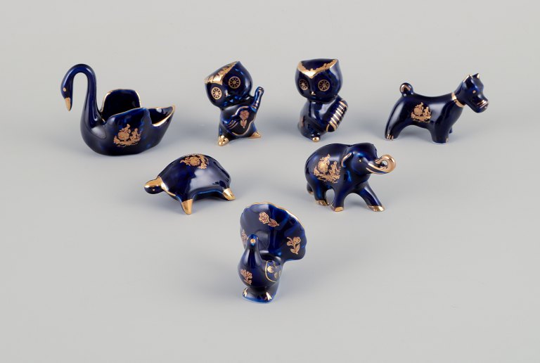 Limoges, Frankrig.  Syv miniaturedyr i porcelæn. Dekoreret i 22-karat bladguld. Smuk kongeblå glasur. Scène galante.