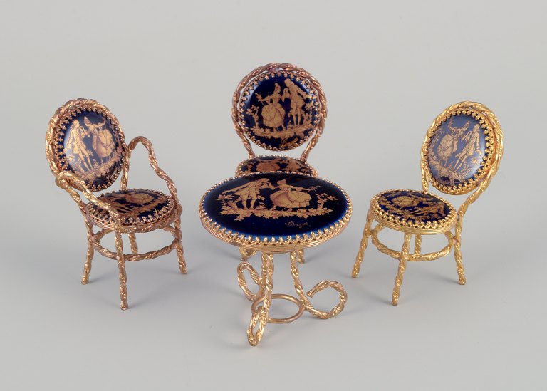 Limoges, Frankrig.  Miniature bord og stole i metal og porcelæn. Dekoreret i 22-karat bladguld. Smuk kongeblå glasur. Scène galante.