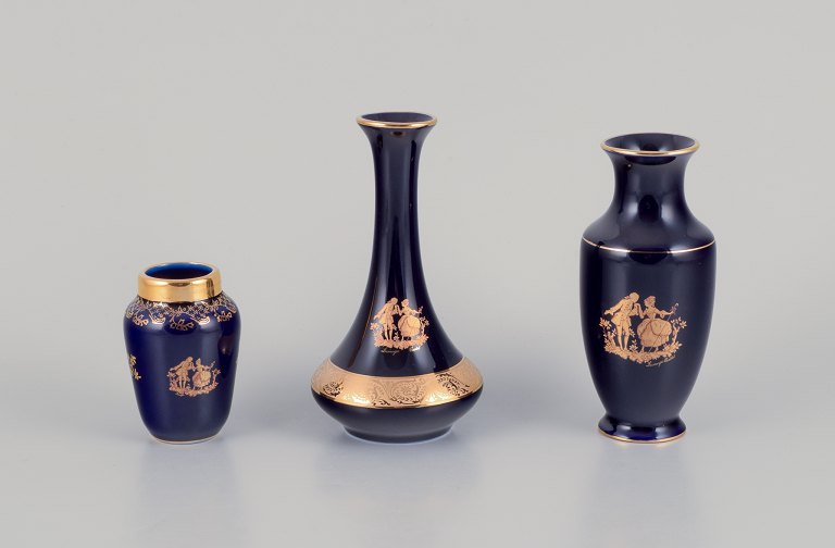 Limoges, Frankrig.  Tre små vaser i porcelæn. Dekoreret i 22-karat bladguld. Smuk kongeblå glasur. Scène galante.