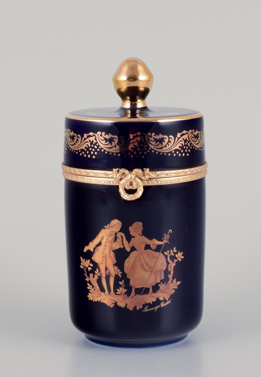 Limoges, Frankrig.  Lågdåse i porcelæn med messingmontering. Dekoreret i 22-karat bladguld. Smuk kongeblå glasur. Scène galante.