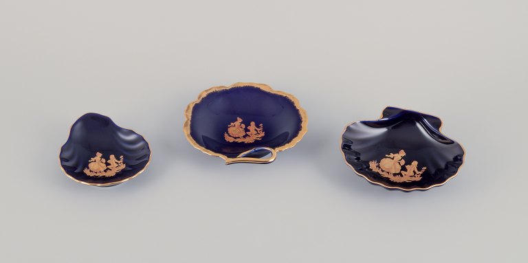 Limoges, Frankrig. Tre skåle i porcelæn dekoreret i 22-karat bladguld og smuk kongeblå glasur. Scène galante.