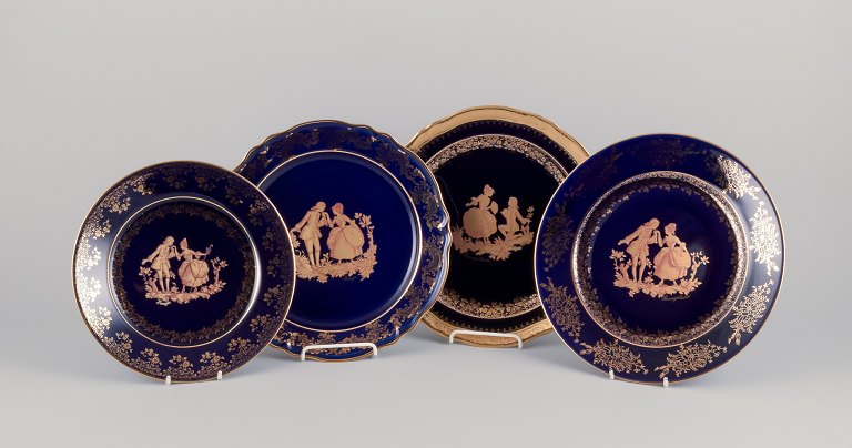 Limoges, France. Four plates in porcelain decorated with 22-karat gold leaf. Beautiful royal blue glaze. Scène galante.