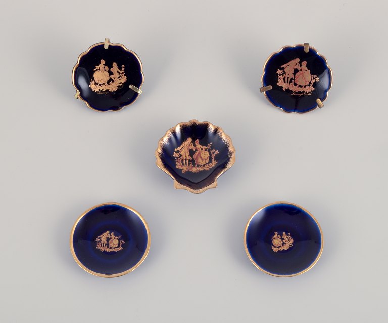 Limoges, Frankrig. Fem små dele porcelæn dekoreret i 22-karat bladguld. Smuk kongeblå glasur. Scène galante.