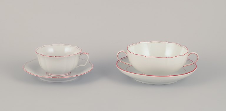 Meissen, Germany. Tea cup and bouillon cup with saucers. Decorated with coral red and gold-colored trim. Art Deco.