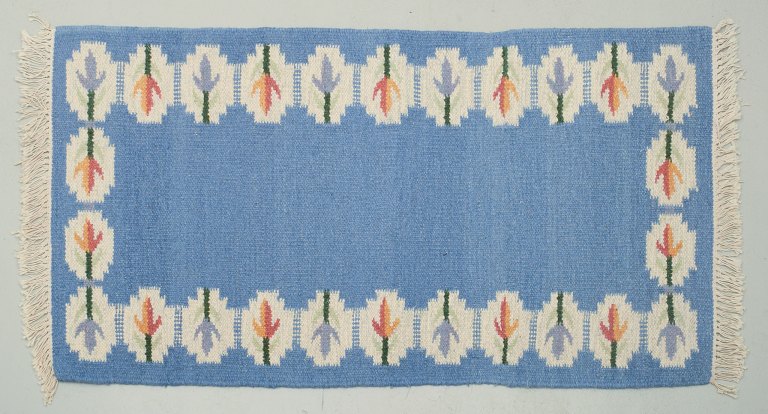 Svensk håndvævet tæppe i ren uld. Rölakan teknik.Designet med blomster på blå bund.