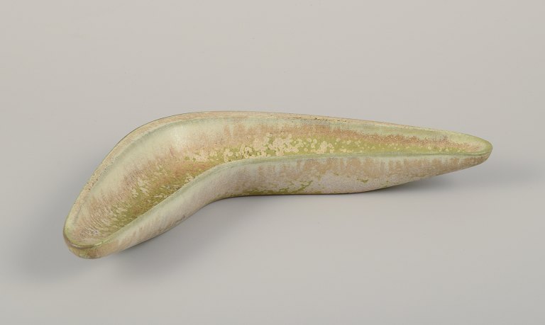 Gunnar Nylund for Rörstrand. Boomerang-shaped ceramic bowl.Eggshell glaze in light green and sand-colored tones.