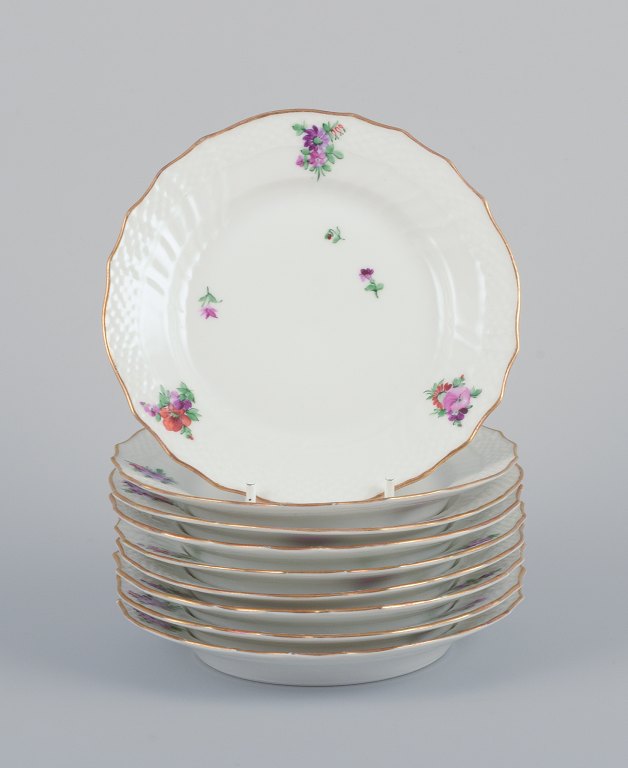 Royal Copenhagen Saxon Flower. Nine porcelain plates. Hand-painted with polychrome flowers. Gold rim.