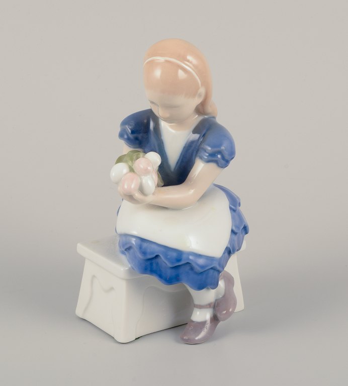 Bing & Grøndahl, Denmark.Porcelain figurine of seated girl with a bouquet of flowers in her arms.