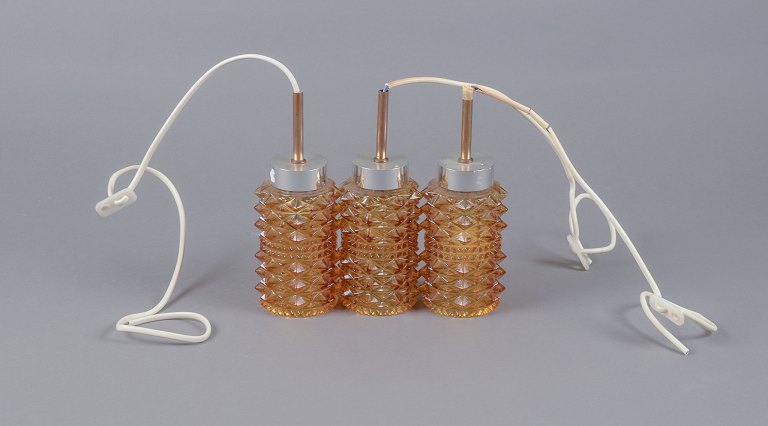 Helena Tynell.Three small ceiling lamps in stainless steel and smoke-colored glass.