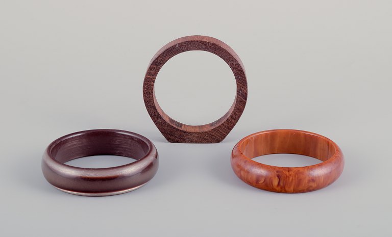 Fransk smykkedesigner.Tre armbånd. To i plast og et i træ. Ravfarvet samt i brune nuancer.