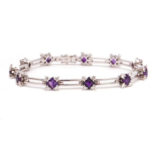 Leddelt armbånd i 18kt hvidguld med kasselås og dobbelt sikkerhedslås prydet med 11 ametyster flankeret af hver 4 diamanter på ca. 0,03ct. I alt ca. 1,32ct. L: 18,5cm