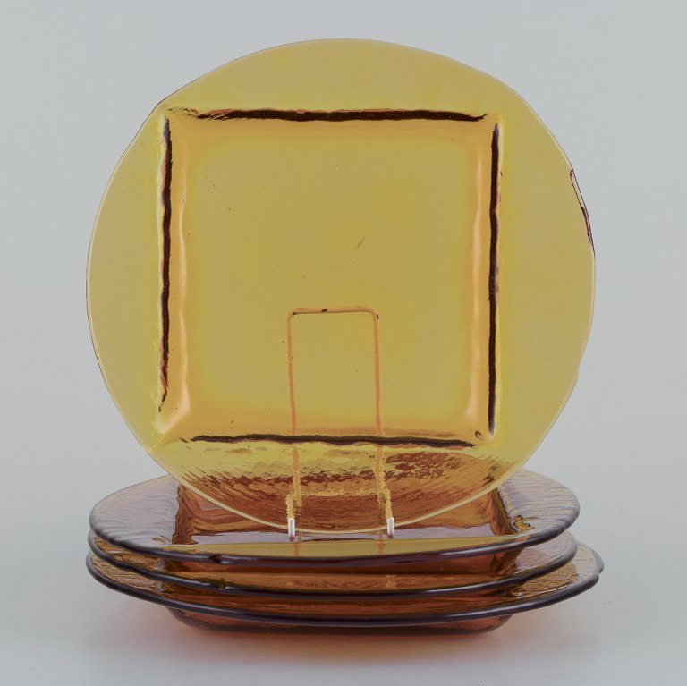 Scandinavian glass designer. A set of four dinner plates in smoke-coloured art glass.