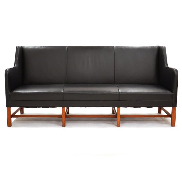 Kaare Klint three-seater sofa 5011 upholstered in black leather. Manufactured by Rud. Rasmussen. The black leather is in a good condition and the frame with minor signs of use. H: 92cm. L: 194cm. D: 65cm