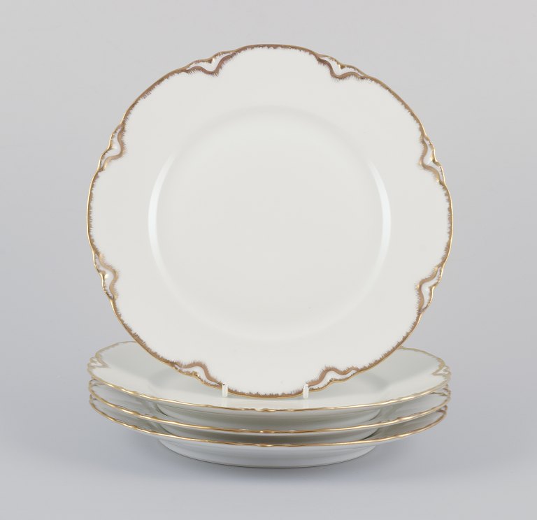 A set of four Haviland porcelain dinner plates.Hand-decorated gold decoration, white porcelain.