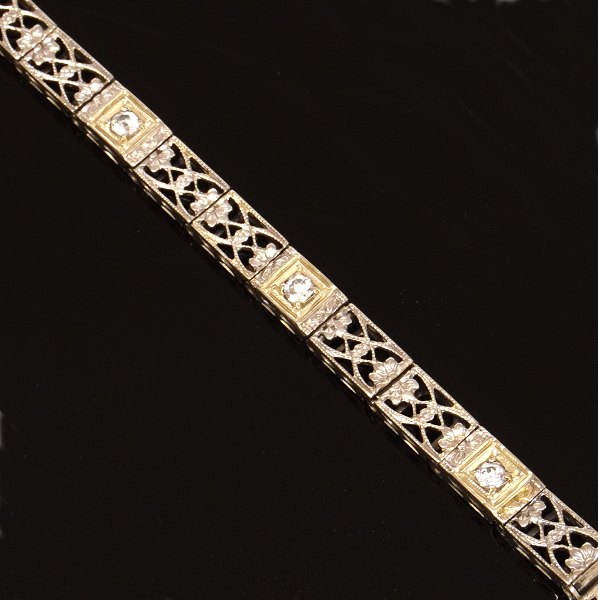 14kt hvidguld leddelt armlænke prydet med gennembrudte dekorationer og tre diamanter ca. 0,25ct i alt. L: 18,5cm. B: 4,5mm