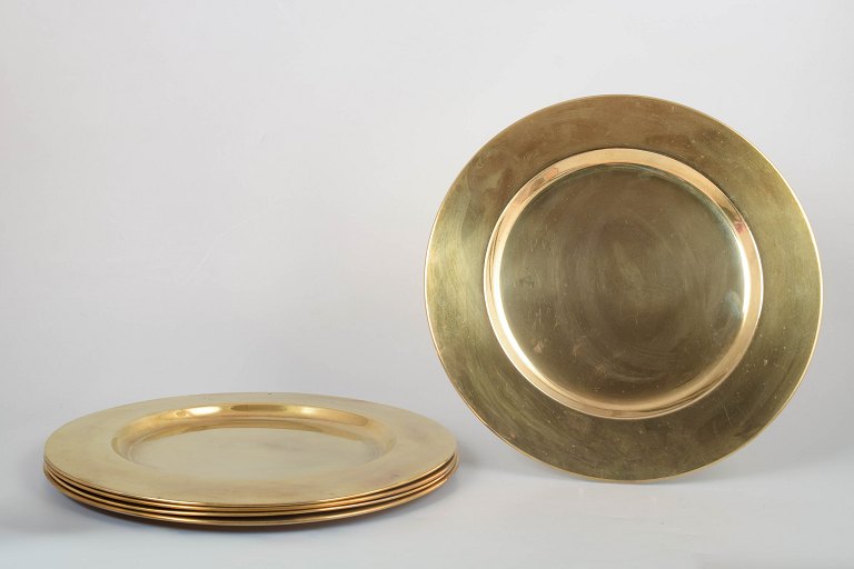 Set of five brass charger plates.